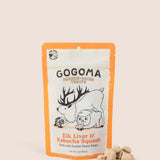 A stand-up pouch of Gogoma freeze-dried pet treats on a warm beige background, with several small bite-sized treats placed in front of the package. The package is white with orange border and printed black and orange text and illustrations of an elk and sweet potato.